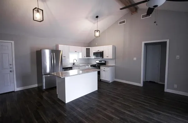 a kitchen with stainless steel appliances granite countertop a refrigerator and a stove top oven