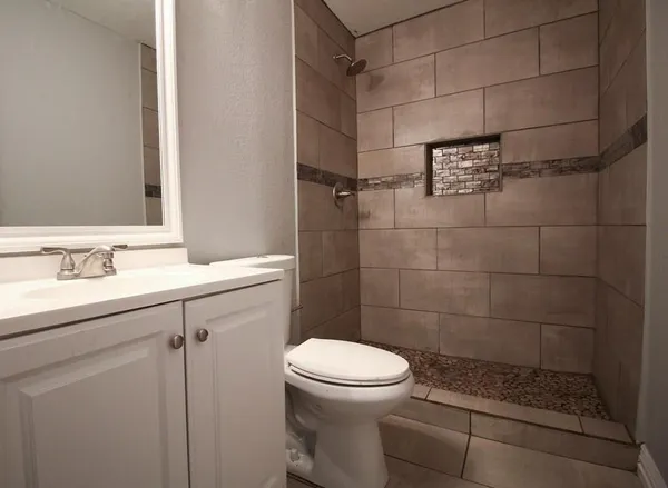 a bathroom with a sink a toilet and shower