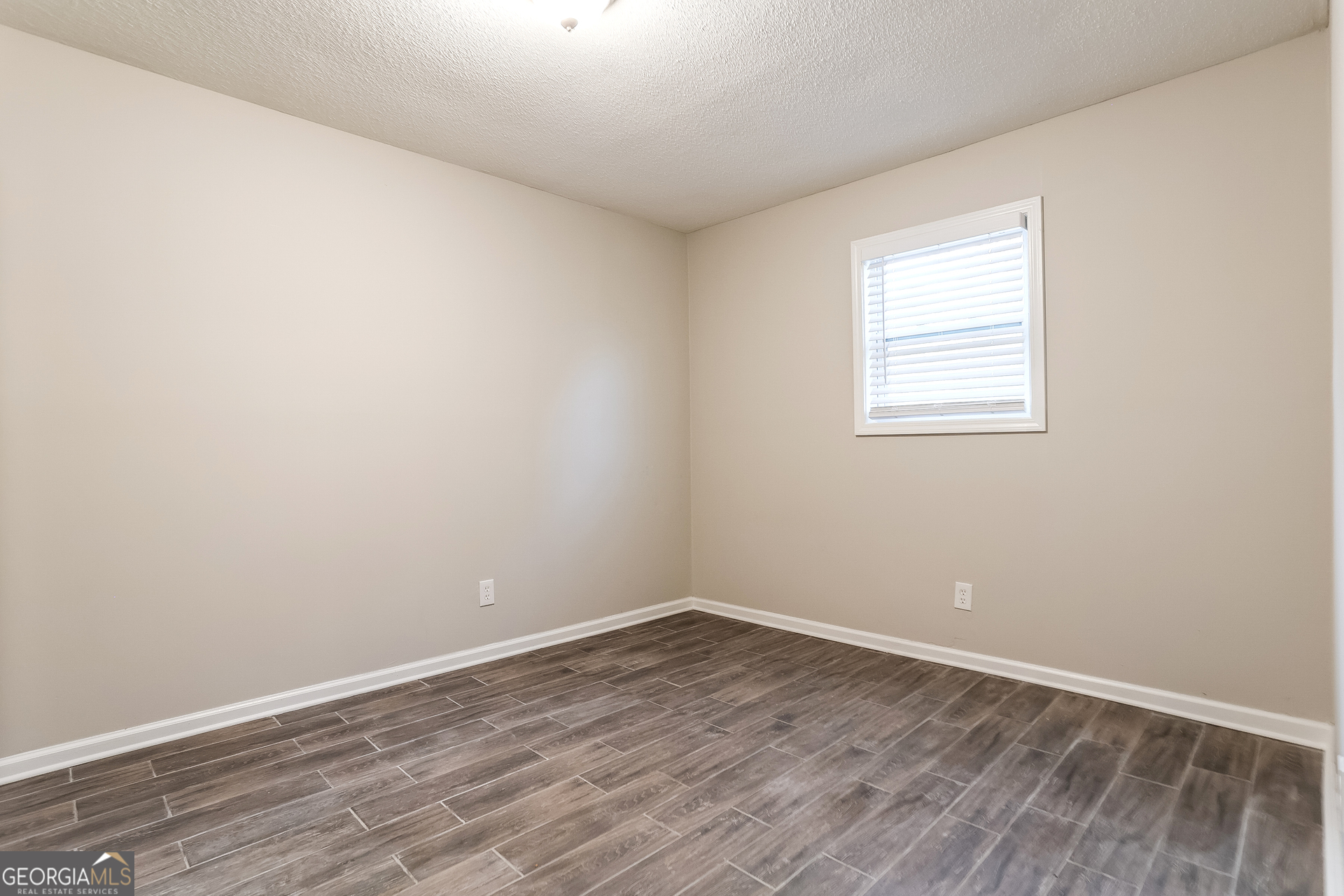 8621 Chestnut Lane Lithia Springs, GA 30122 - Photo 14 of 16 an empty room with wooden floor and windows