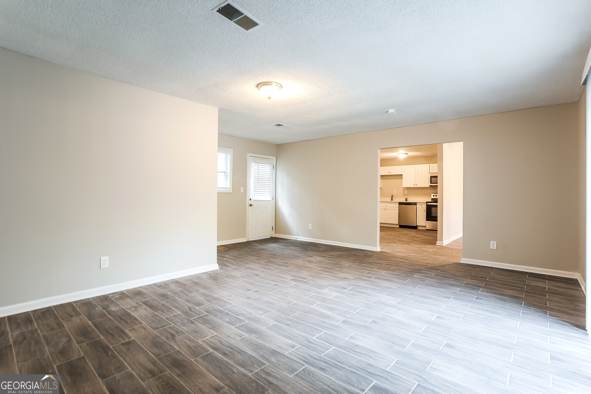 8621 Chestnut Lane Lithia Springs, GA 30122 - Photo 8 of 16 wooden floor in an empty room with a window