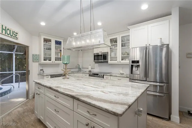 a kitchen with stainless steel appliances granite countertop a sink refrigerator and cabinets