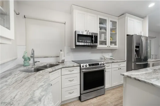 a kitchen with stainless steel appliances granite countertop a stove a sink and a refrigerator