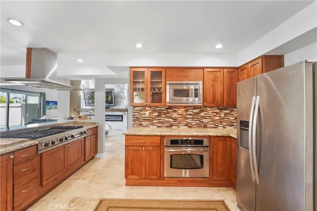 a kitchen with stainless steel appliances granite countertop a stove a refrigerator and a stove