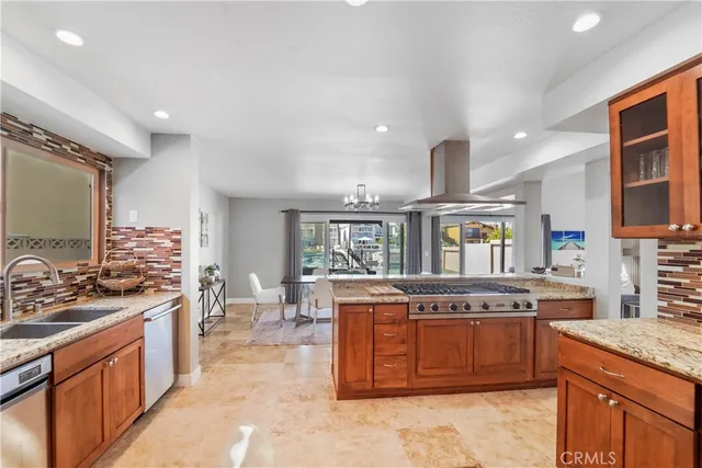 a kitchen with stainless steel appliances granite countertop a stove a sink and a refrigerator