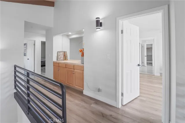 a view of a hallway with entryway and wooden floor