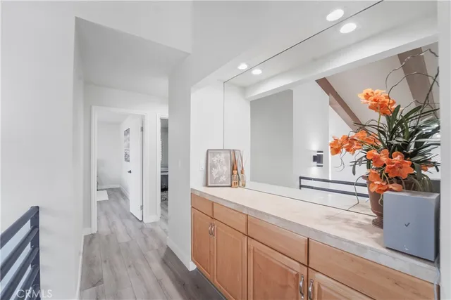 a view of a hallway to a livingroom with wooden floor and furniture