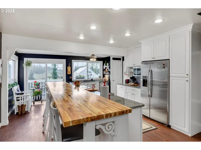 a kitchen with stainless steel appliances granite countertop a sink and a refrigerator