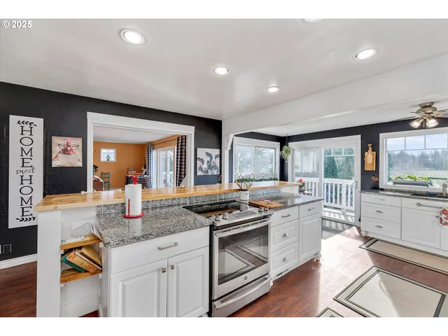 a kitchen filled with stainless steel appliances granite countertop a sink a stove and a window