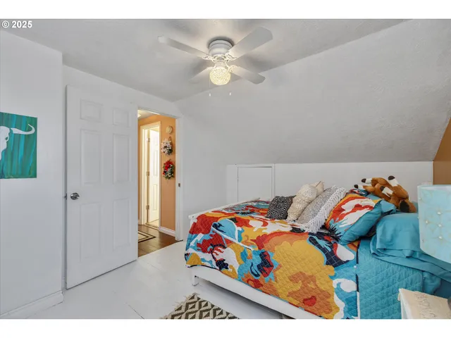 a bedroom with a bed and a painting on the wall