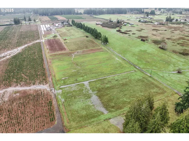 a view of a lake with a yard and trees in the background