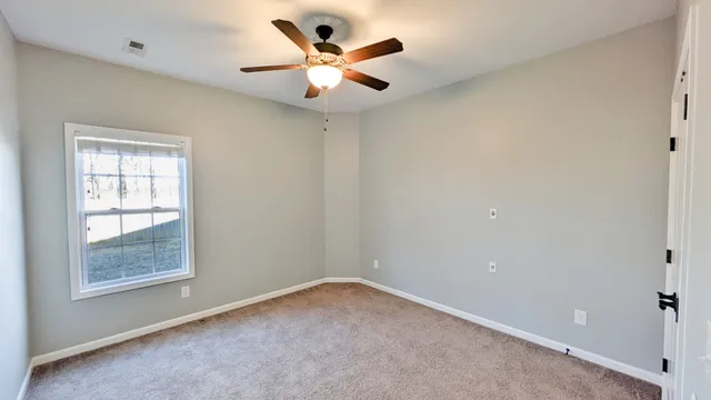 a view of a room with a ceiling fan and a fan