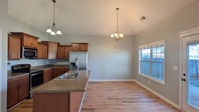 a kitchen with granite countertop stainless steel appliances a stove top oven a sink and dishwasher