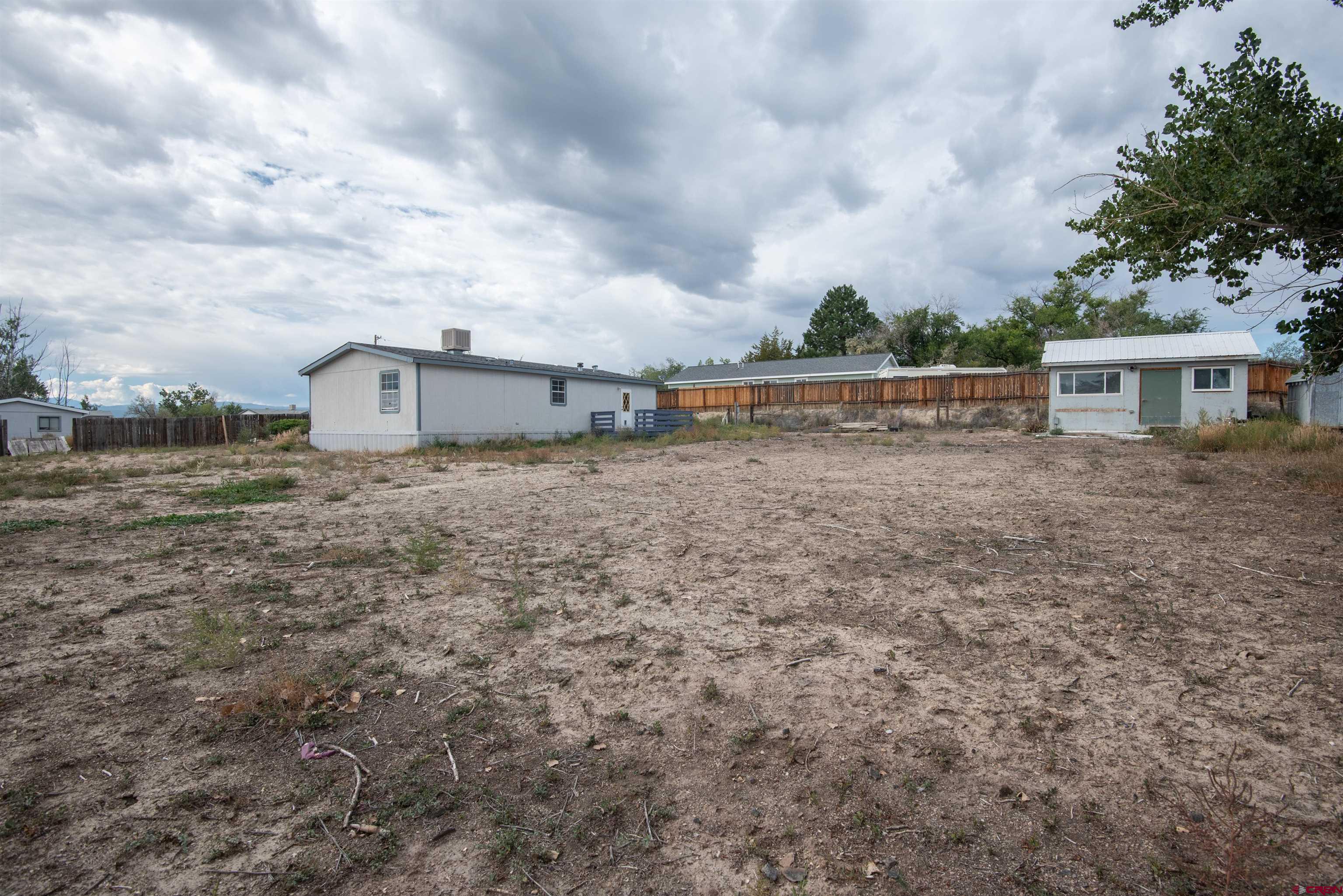 67135 N Road Montrose, CO 81401 - Photo 12 of 33 a backyard of a house with lots of green space
