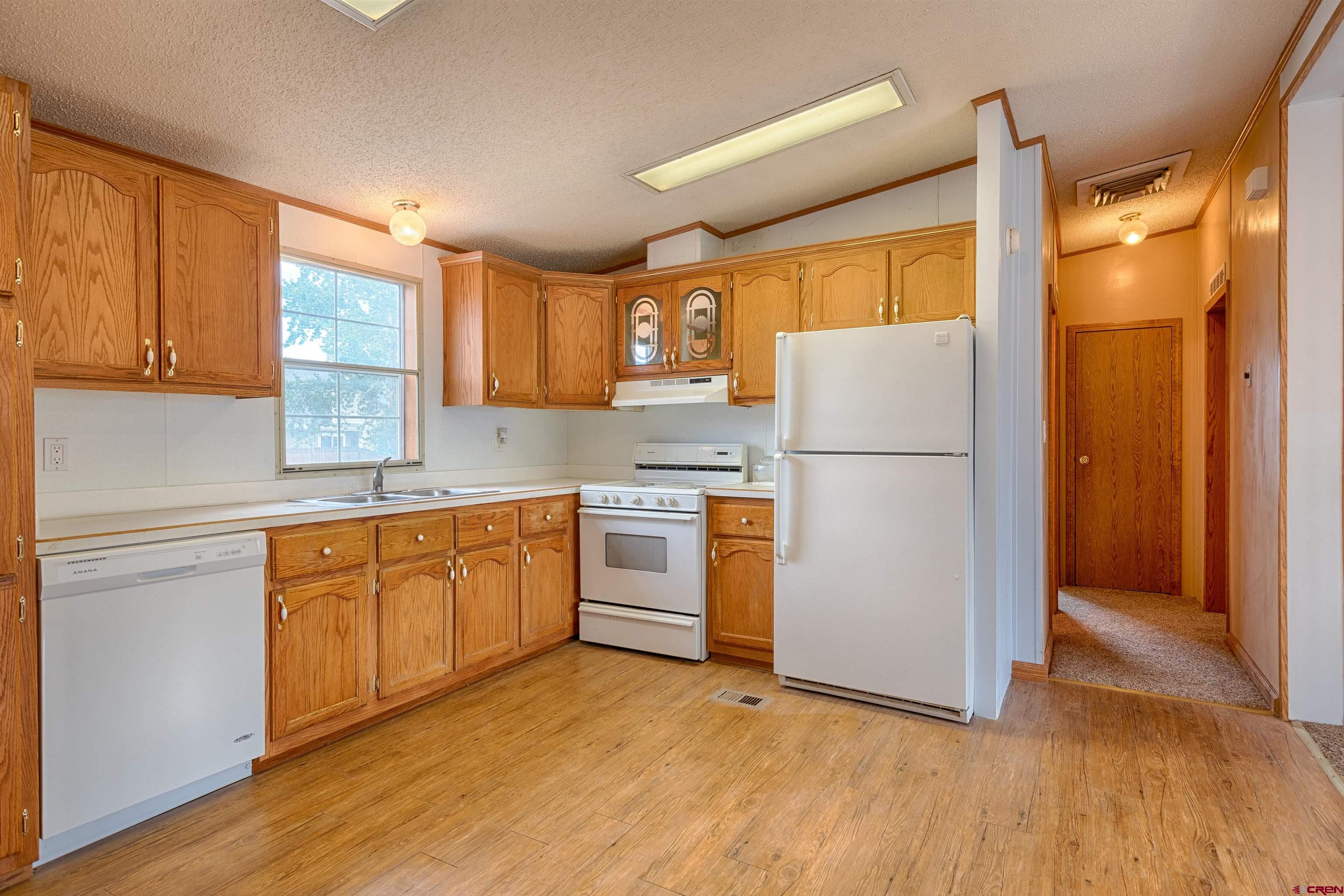 67135 N Road Montrose, CO 81401 - Photo 19 of 33 a kitchen with a refrigerator a stove top oven and cabinets