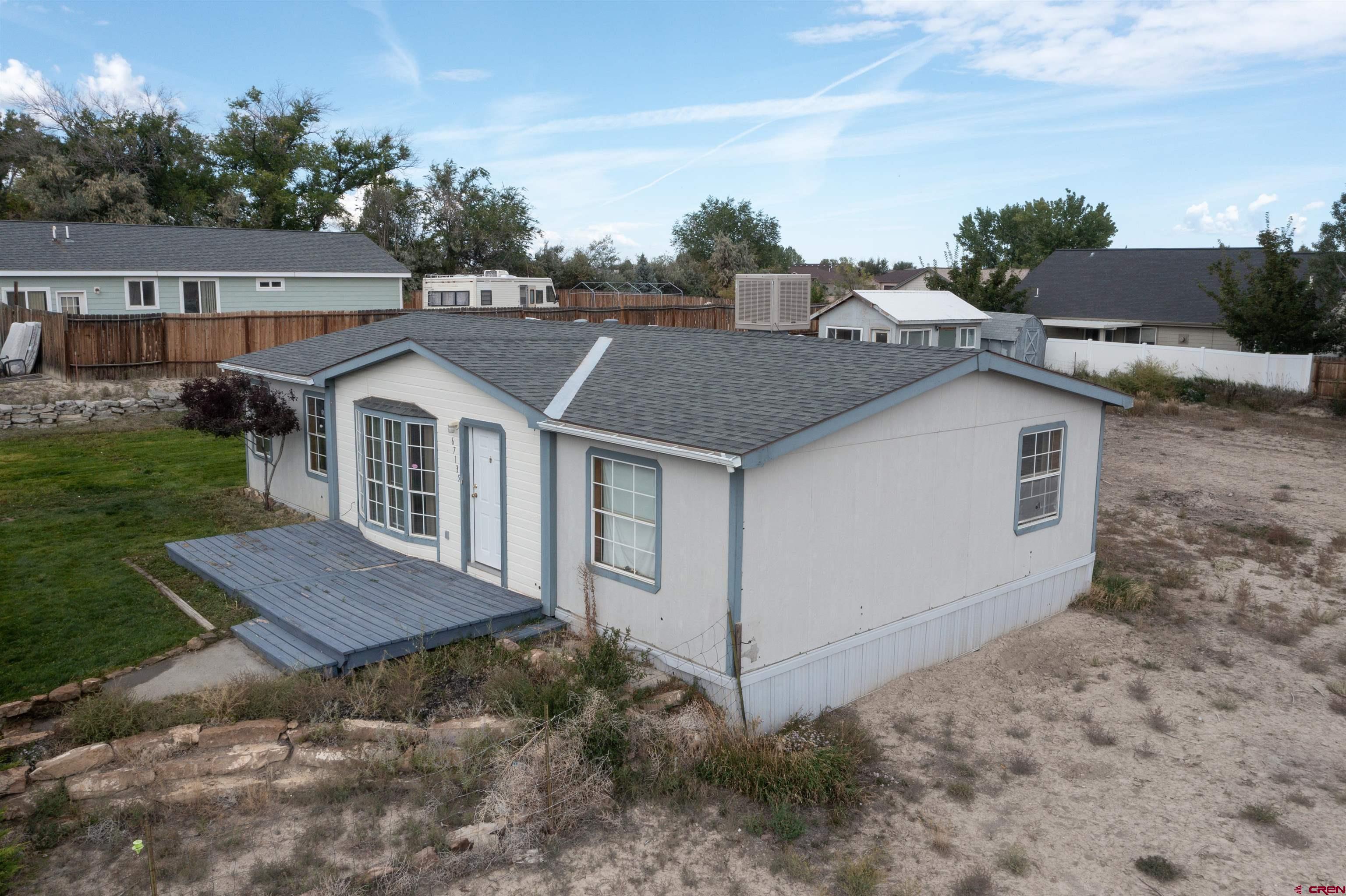67135 N Road Montrose, CO 81401 - Photo 4 of 33 a view of house with yard and trees in the background