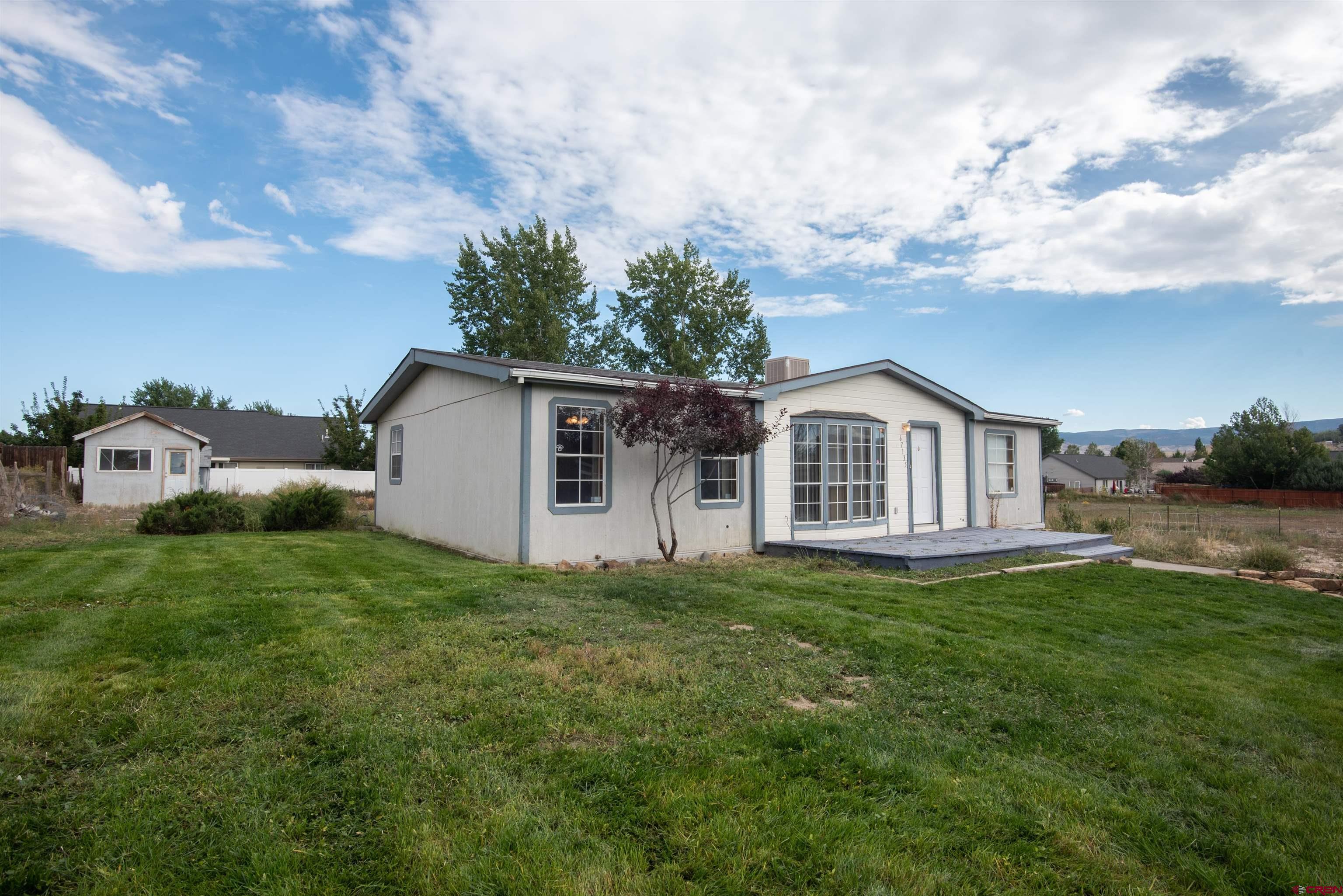 67135 N Road Montrose, CO 81401 - Photo 5 of 33 a front view of a house with garden