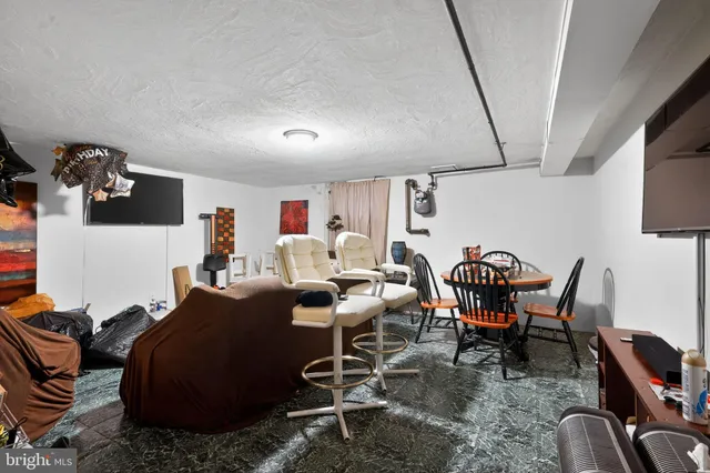 a living room with furniture a rug and white walls