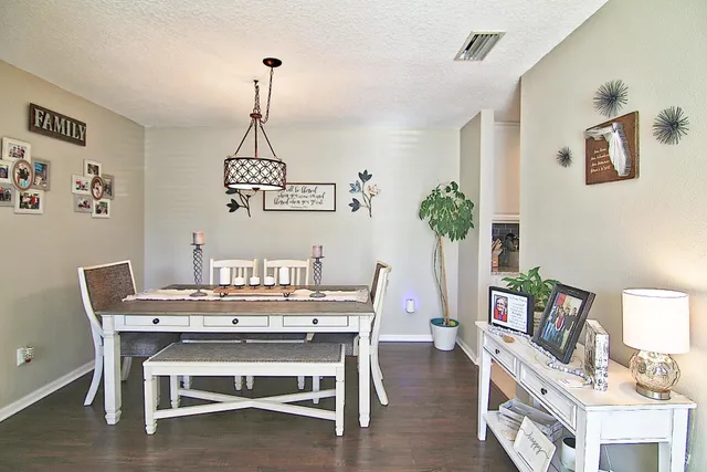 a dining room with furniture potted plants and wooden floor