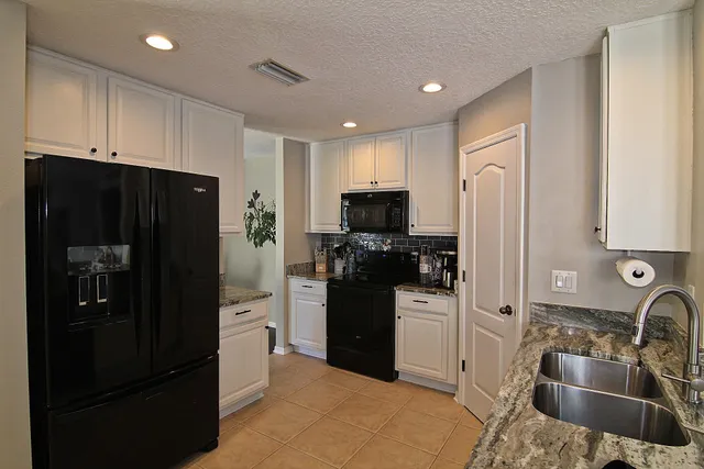 a kitchen with stainless steel appliances granite countertop a refrigerator and a sink