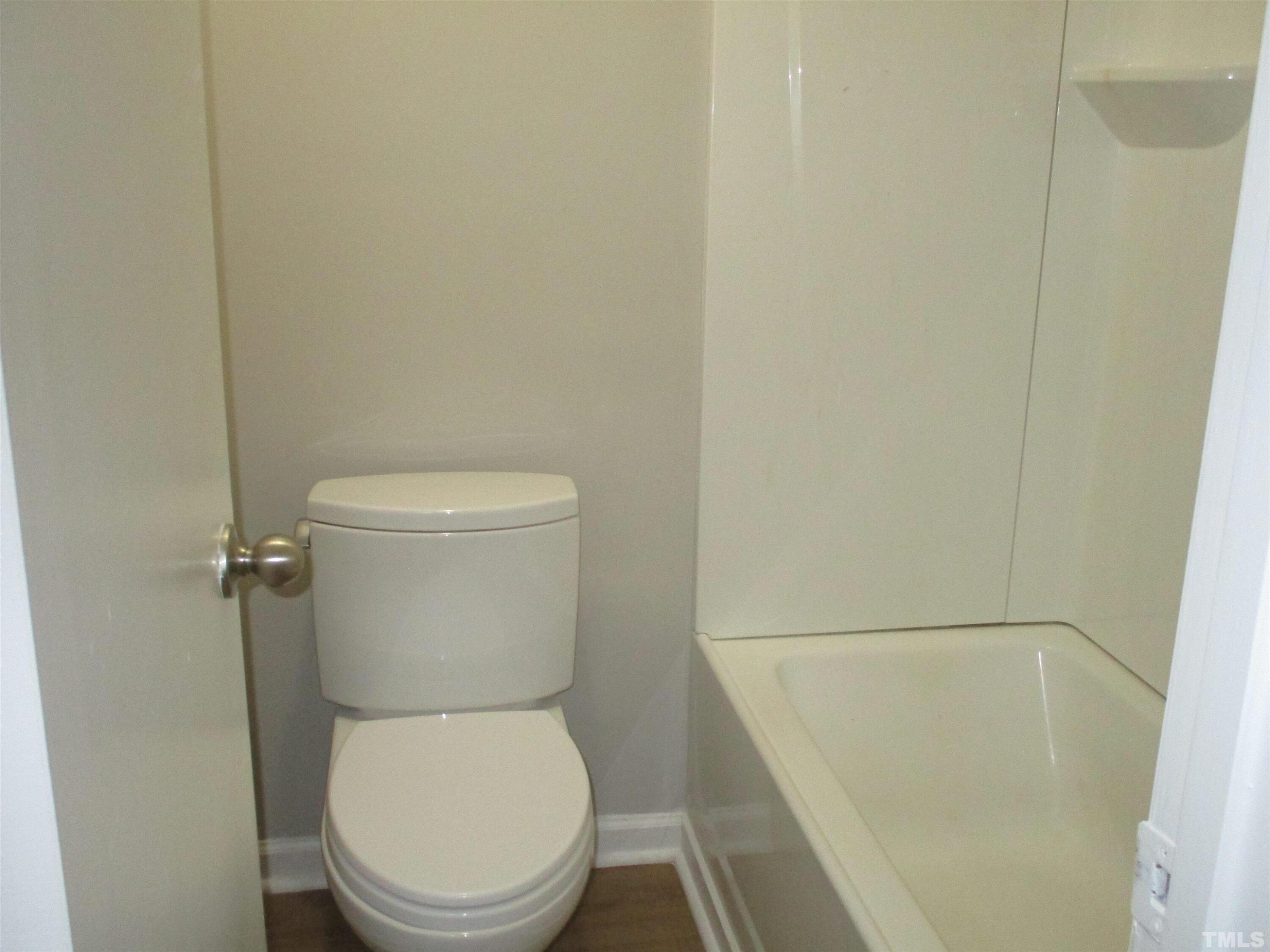 6435 New Market Way Raleigh, NC 27615 - Photo 10 of 17 a white toilet sitting next to a white sink and vanity