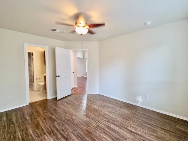 a view of an empty room with wooden floor