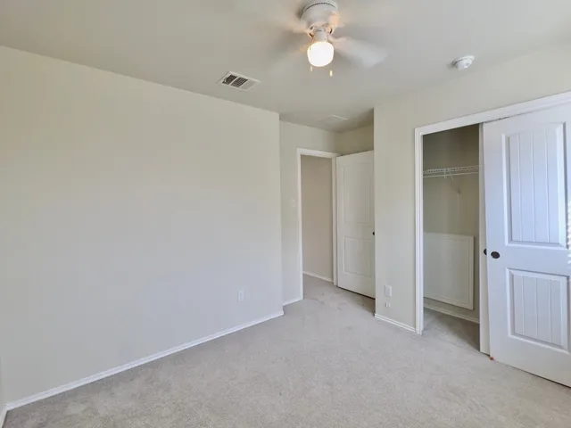 an empty room with a empty space and a ceiling fan