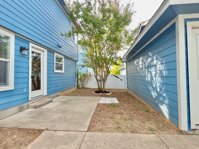 a view of a backyard with brick wall and a large tree