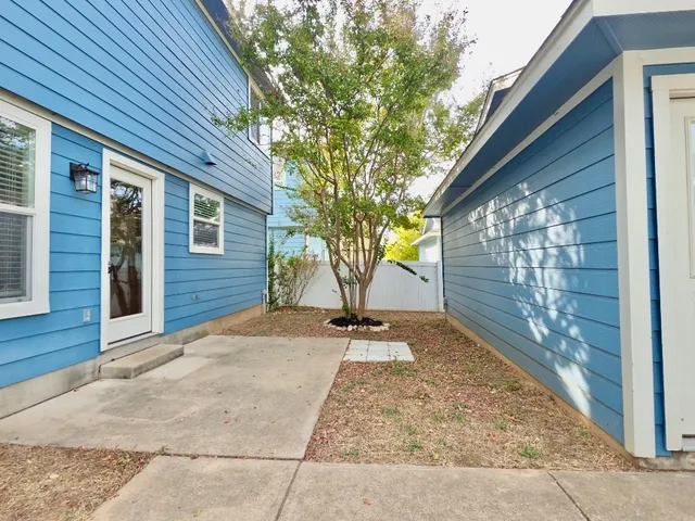 a view of a backyard with brick wall and a large tree