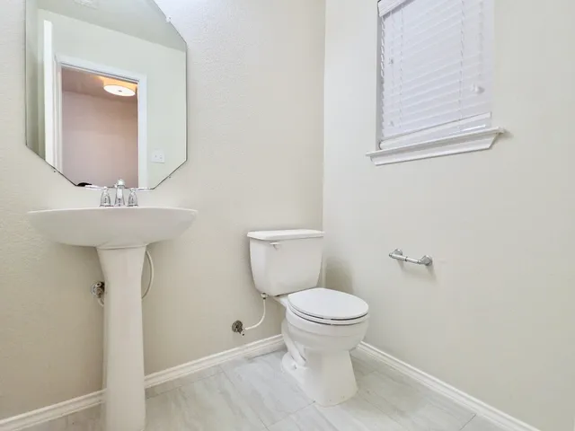a bathroom with a sink toilet and a mirror