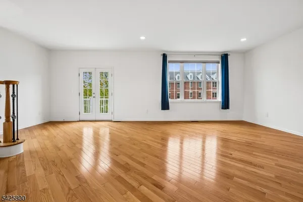 en empty room with windows and ceiling fan