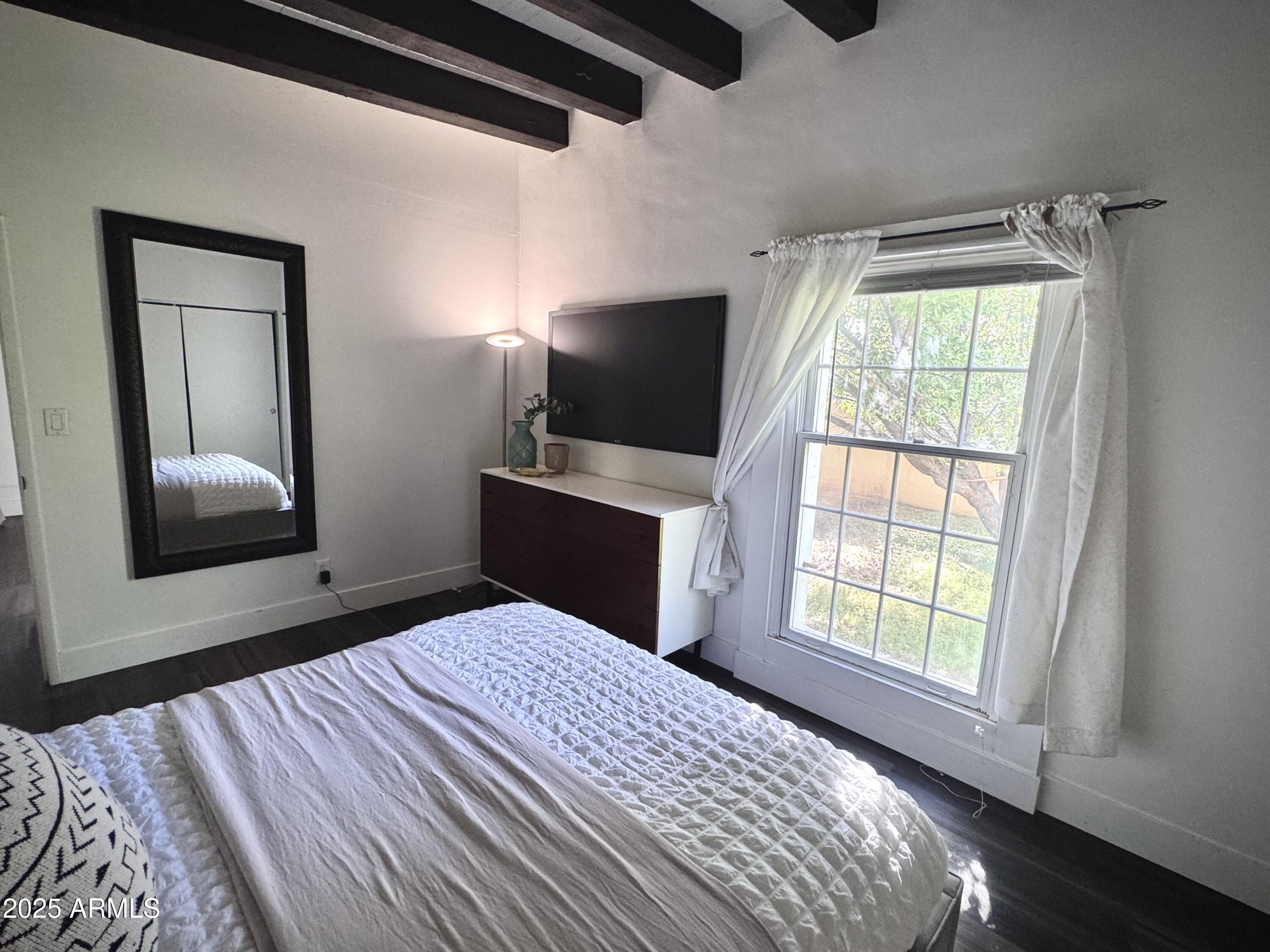 3134 North 28th Street Phoenix, AZ 85016 - Photo 14 of 21 a bedroom with a bed and a flat tv screen on a dresser