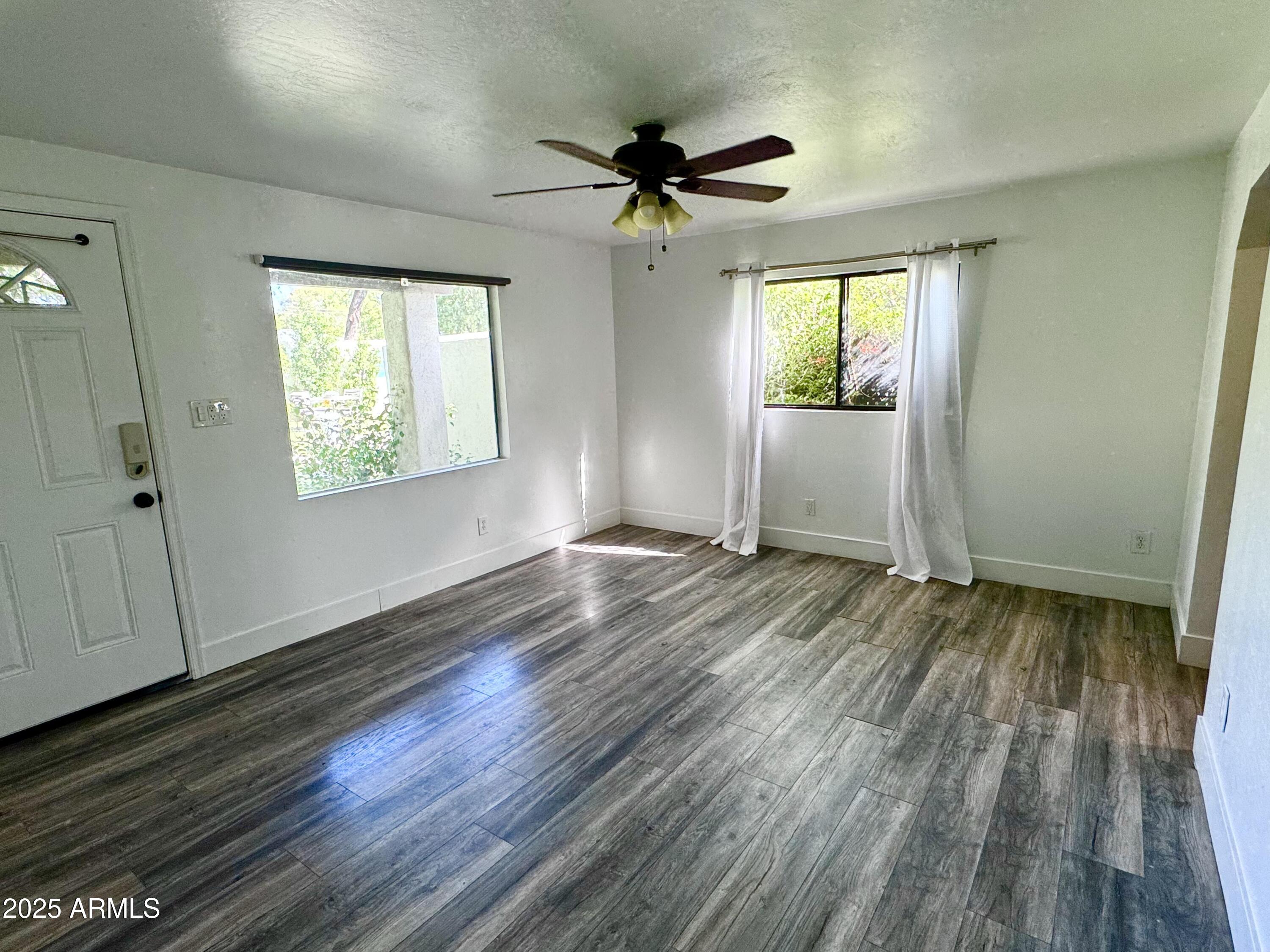3134 North 28th Street Phoenix, AZ 85016 - Photo 18 of 21 a view of an empty room with wooden floor and a window