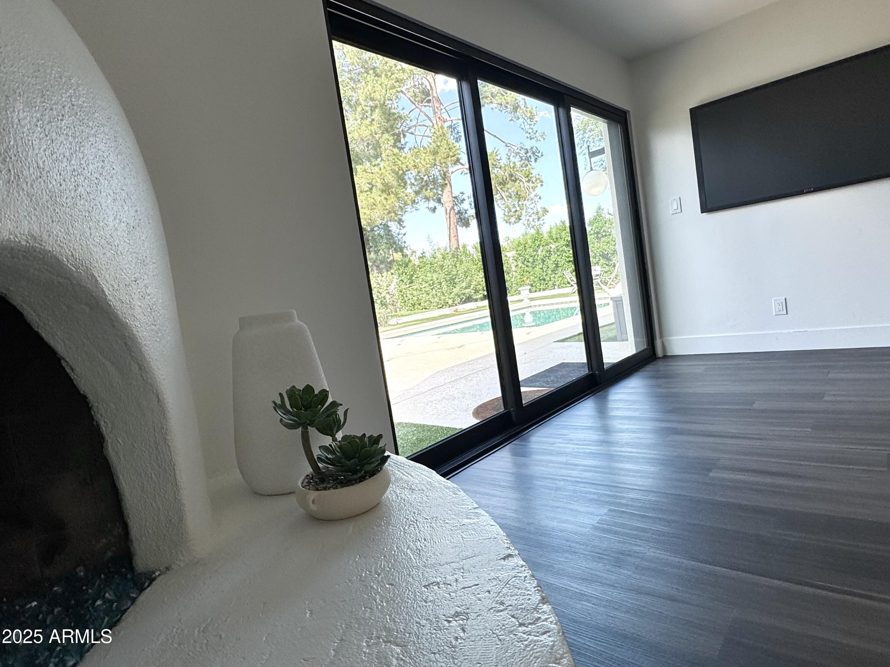 3134 North 28th Street Phoenix, AZ 85016 - Photo 10 of 21 a view of a hallway with wooden floor and a flat screen tv