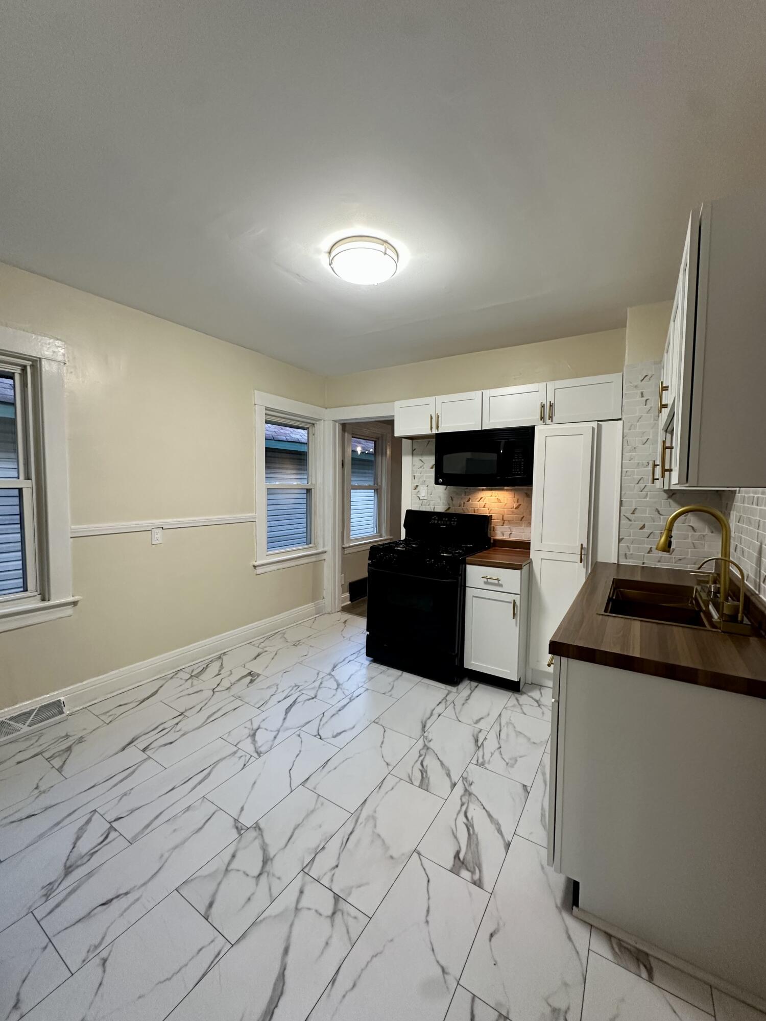 6244 Madison Avenue Hammond, IN 46324 - Photo 11 of 21 a large kitchen with granite countertop a sink and white cabinets