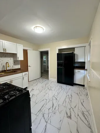 a kitchen with granite countertop a refrigerator and a stove top oven