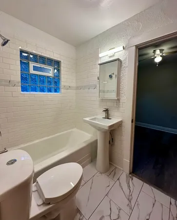 a bathroom with a sink a toilet and bathtub