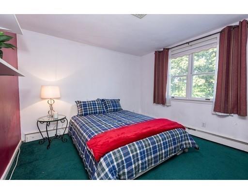 4 Rivers Lane Stoneham, MA 02180 - Photo 33 of 42 a bedroom with a bed a window and a chandelier