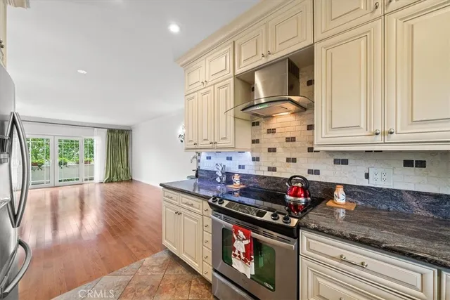 a kitchen with stainless steel appliances granite countertop a stove and a wooden cabinets