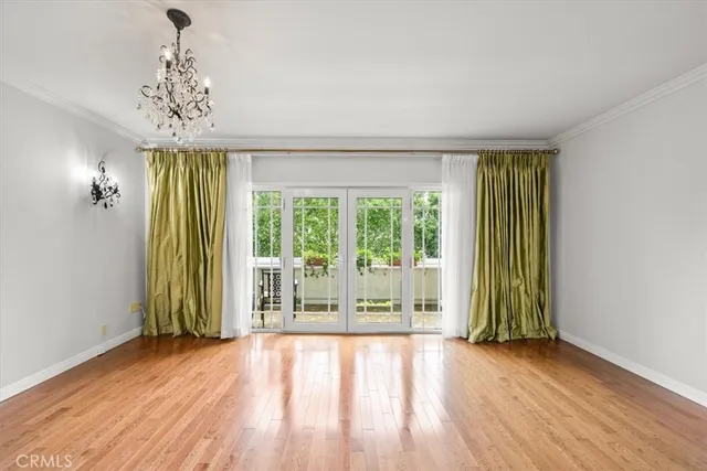a view of a room with wooden floor and a large window