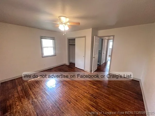 a view of a livingroom with wooden floor and a ceiling fan