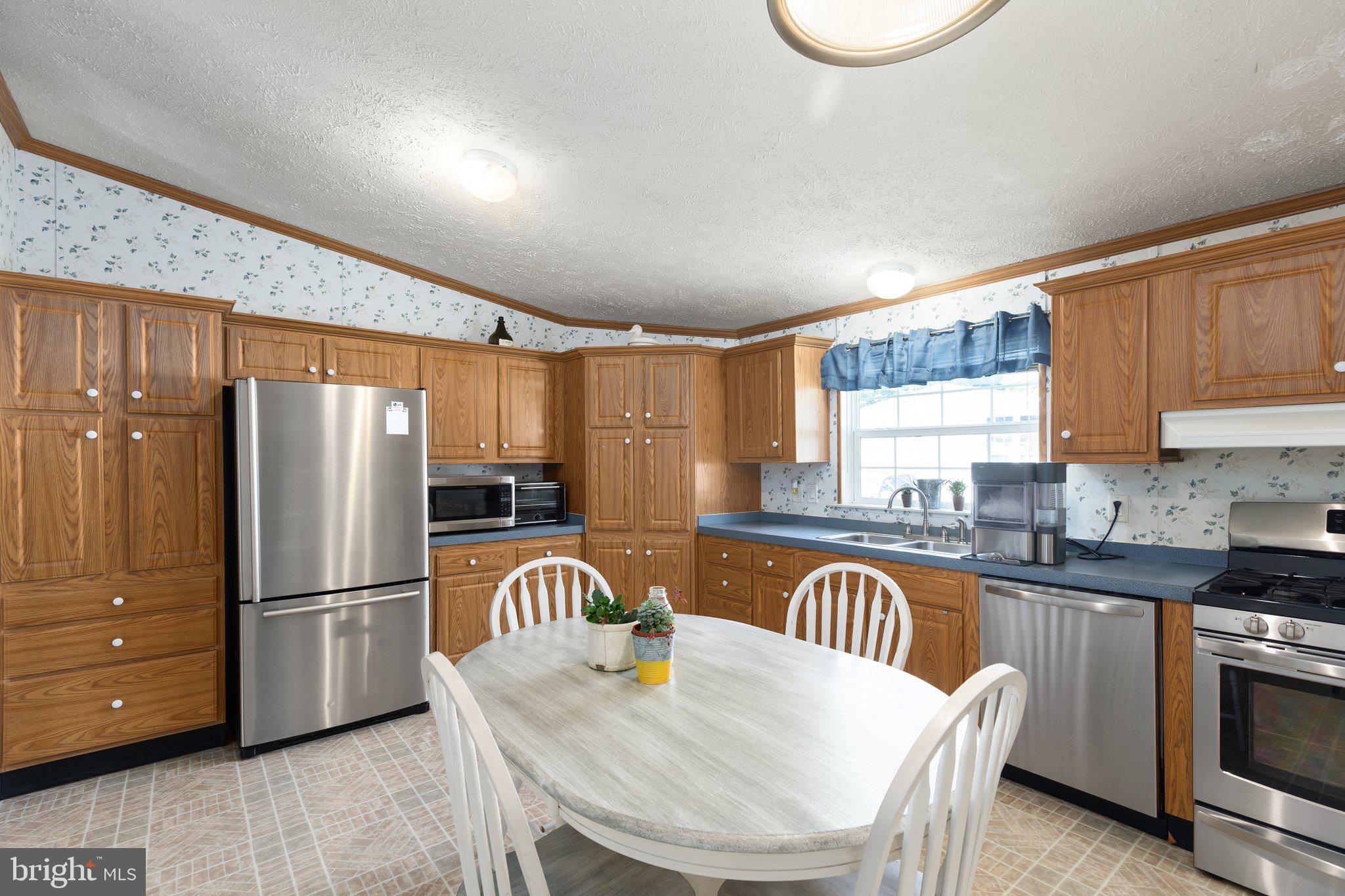 4041 Conowingo Road, Unit 29A Darlington, MD 21034 - Photo 8 of 21 a kitchen with granite countertop a refrigerator a stove a sink and a dining table with wooden cabinet