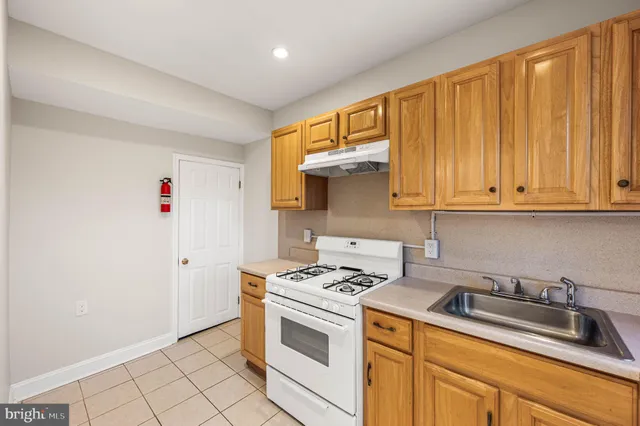 a kitchen with stainless steel appliances granite countertop a sink cabinets and a refrigerator
