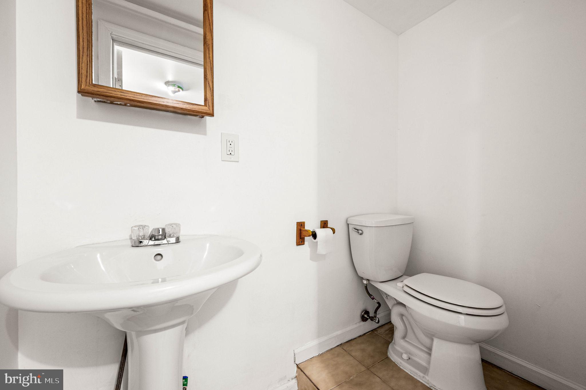 7113 Theodore Street Philadelphia, PA 19142 - Photo 21 of 26 a bathroom with a toilet a sink and a window