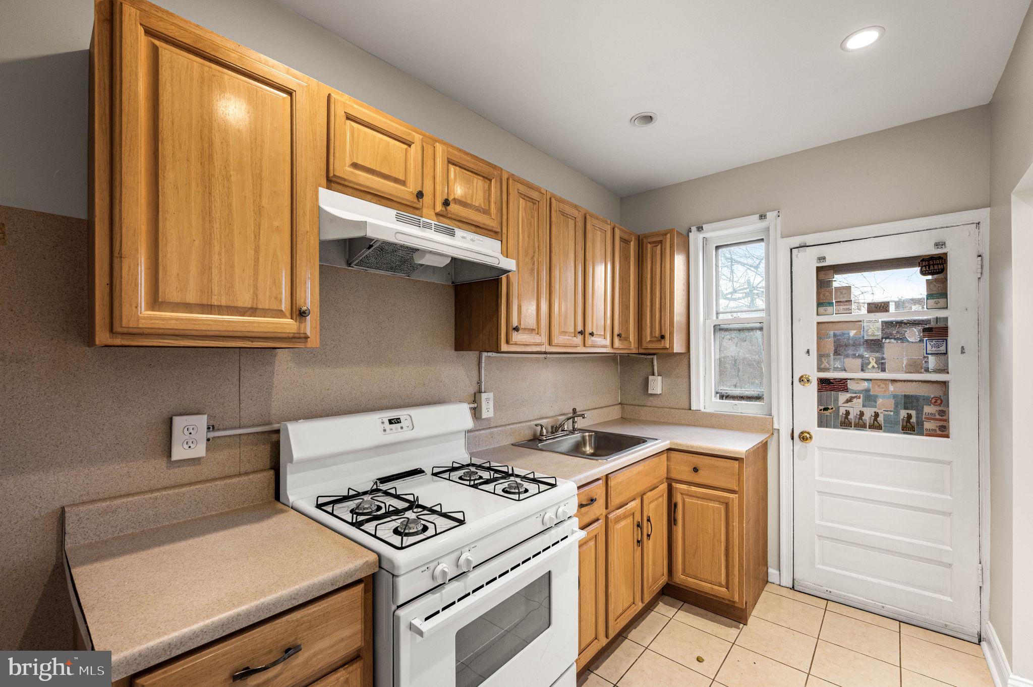7113 Theodore Street Philadelphia, PA 19142 - Photo 9 of 26 a kitchen with a stove and a microwave