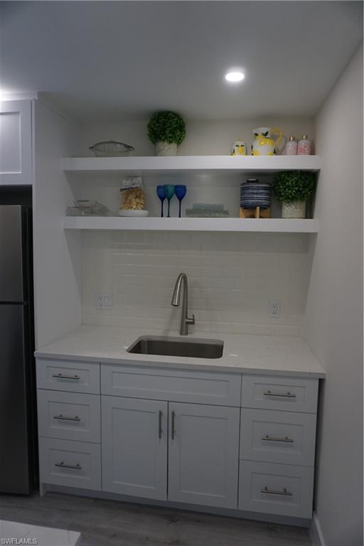 663 12th Avenue South, Unit 663 Naples, FL 34102 - Photo 10 of 14 a kitchen with white cabinets and a sink