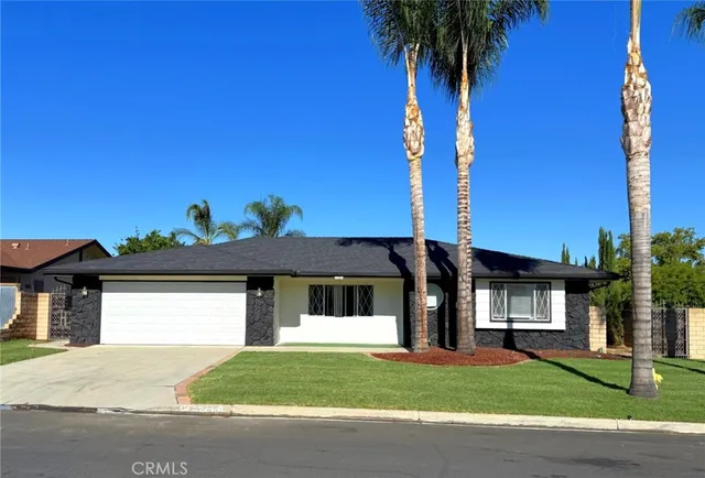 a front view of a house with a garden and yard