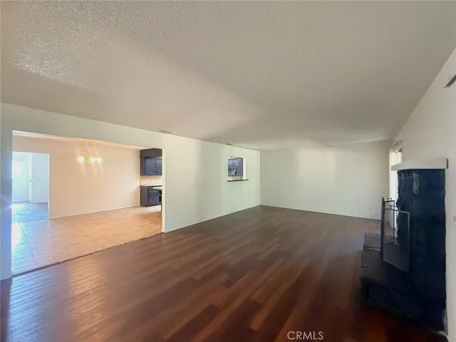 an empty room with wooden floor and fireplace
