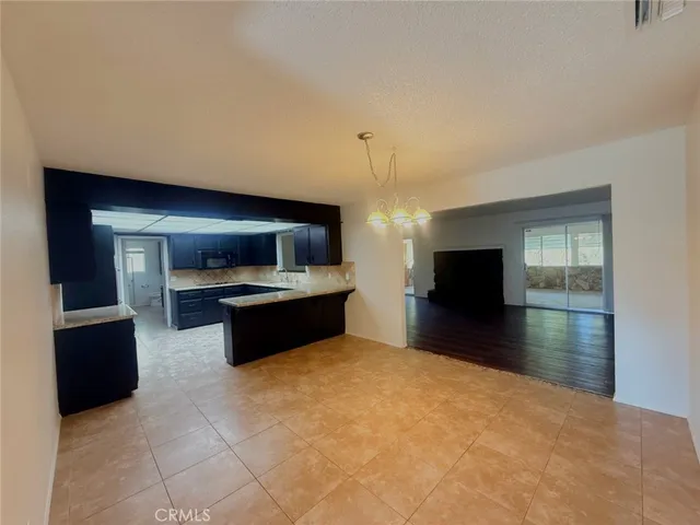 a large kitchen with granite countertop a large counter top and stainless steel appliances