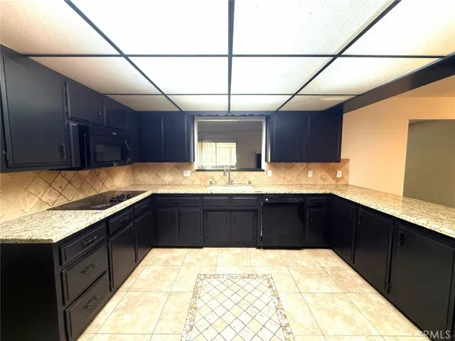 a kitchen with stainless steel appliances kitchen island granite countertop a refrigerator and a sink
