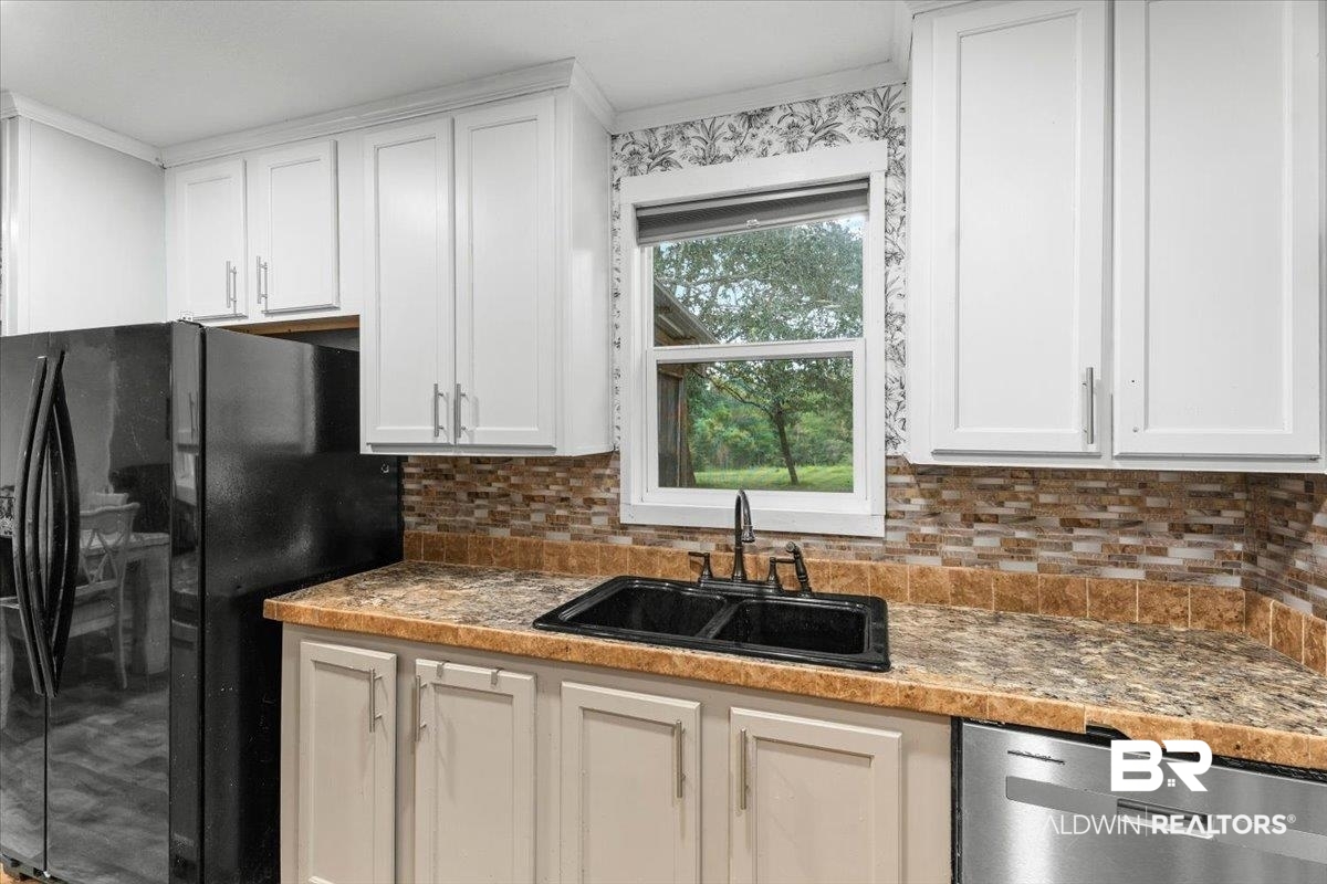 21011 River Road Robertsdale, AL 36567 - Photo 8 of 29 Kitchen featuring white upper cabinetry, light-colored lower cabinetry, a mosaic tile backsplash, a black double-basin sink with a black faucet, and patterned countertops